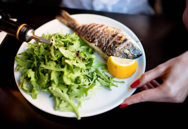 istock Grilled whole sea bream served with rocket salad and lemon 160179148