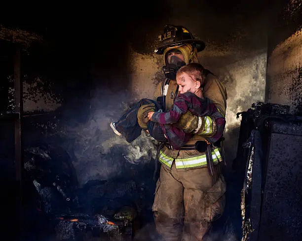 Photo of Firefighter Carrying Boy