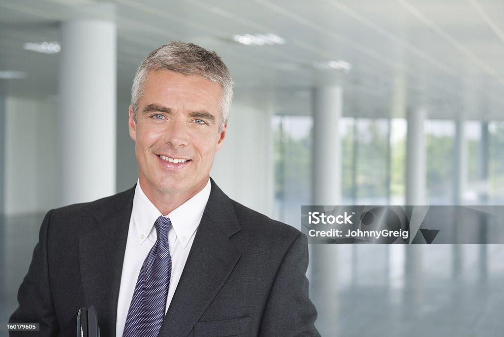 Mature Businessman In Suit Smiling Portrait of smiling mature businessman in lobby of office building. CEO Stock Photo