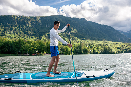Mature Man Stand Up Paddling On A Lake In Slovenia