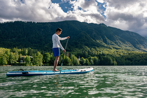 Mature Man Stand Up Paddling On A Lake In Slovenia