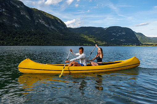 Heterosexual Couple Canoeing Together On A Lake