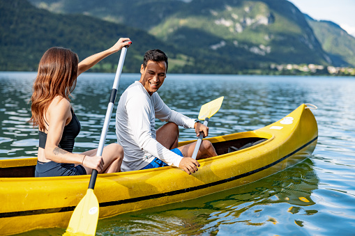 Heterosexual Couple Canoeing Together On A Lake