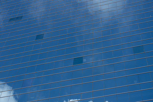 Clouds reflected in windows of modern office building