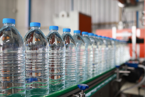A clear of  Drinking water bottles in a conveyer production line , The row of  drinking water bottles on the conveyor belt