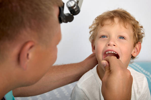 istock Cute boy opened his mouth wide to check the doctor's pride 1601871238