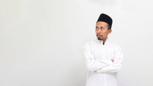 istock Angry young Indonesian man keeps his arms folded, feeling annoyed, isolated on white background 1601878924