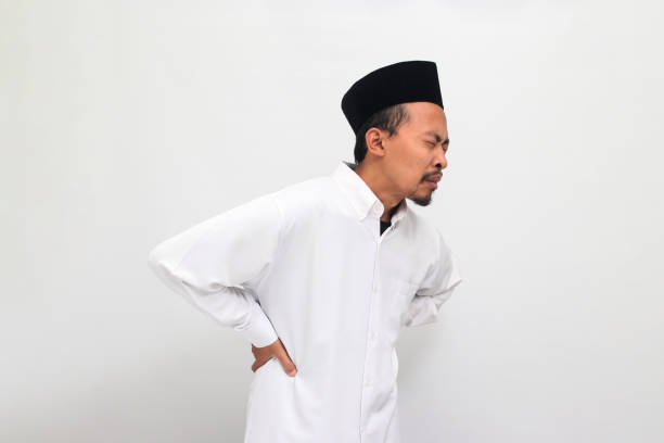 istock Young Indonesian man is suffering and experiencing back pain, isolated on white background 1601882572