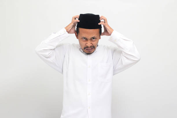 istock Angry young Indonesian man grabs his head, feeling upset, isolated on white background 1601884217