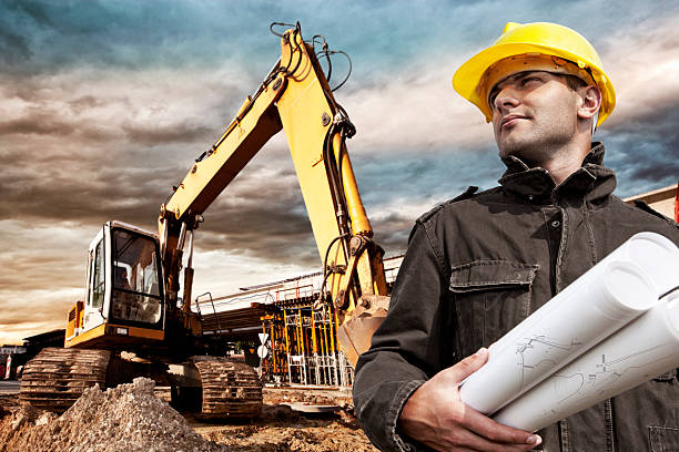 ingénieur sur un chantier de construction - architect construction engineer standing photos et images de collection