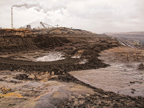 hdr image of open Coal strip mine with smoke stake fumes the air. 