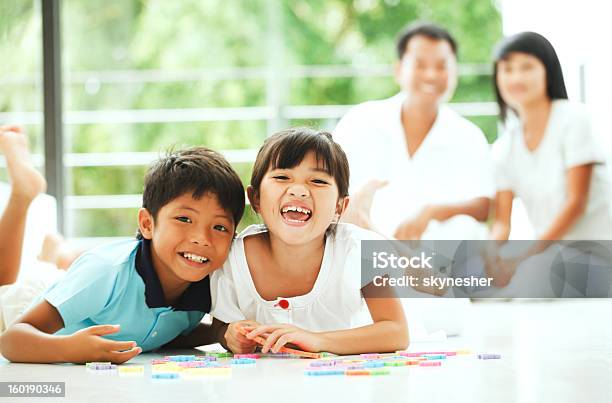 Alegre Niños Jugando Con Un Rompecabezas En Su Hogar Foto de stock y más banco de imágenes de Acostado