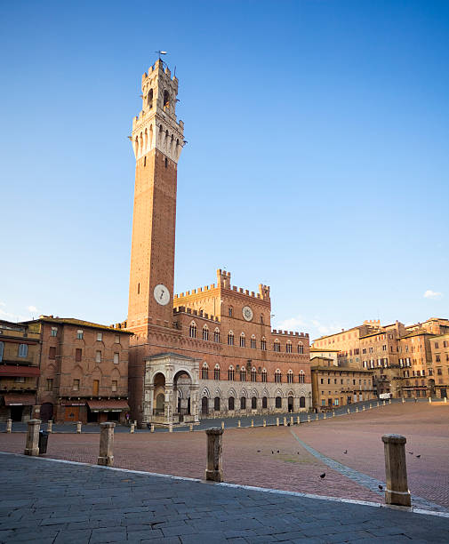 Siena (Tuscany, Italy) Torre del Mangia and town hall on Siena town square - Piazza del Campo. Photo taken early in the morning. torre del mangia stock pictures, royalty-free photos & images