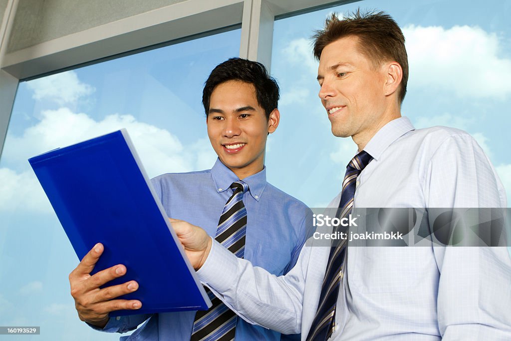 Business men sharing information Two business managers are sharing information on a digital tablet. Document Stock Photo