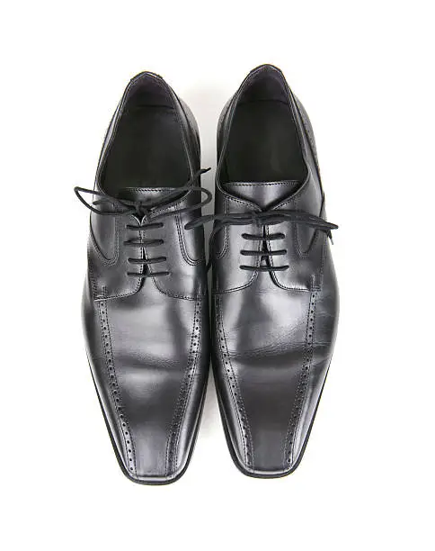 Well-designed black dress shoes with drop shadow and clipping path.