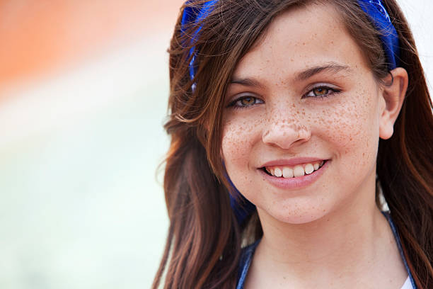 Cute girl grimacing in a T-shirt in the summer outdoors. Photo close-up from the front