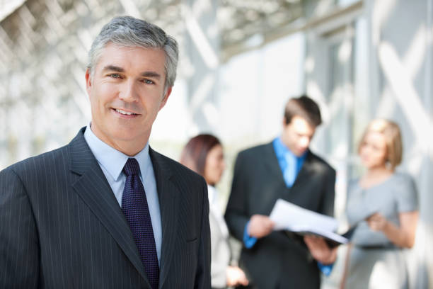 istock Businessman Smiling With Colleagues In Background 160195764