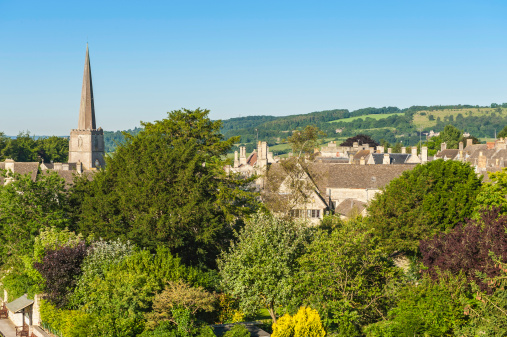 Bright blue skies over the slender church spire and cosy country homes of this picturesque leafy village. ProPhoto RGB profile for maximum color fidelity and gamut.