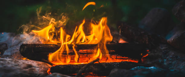 istock Vivid smoldered firewoods burned in fire close-up. Atmospheric warm background with orange flame of campfire. Unimaginable full frame image of bonfire. Burning logs in beautiful fire. Wonderful flame. 1601967937