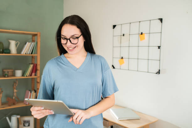 istock Happy woman using digital tablet at home 1601976135