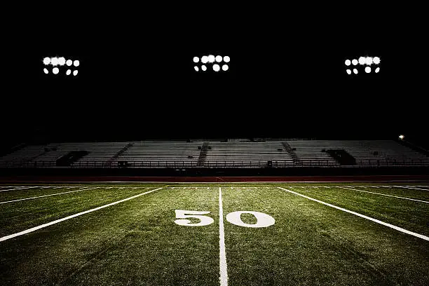 Photo of Fifty-yard line of football field at night