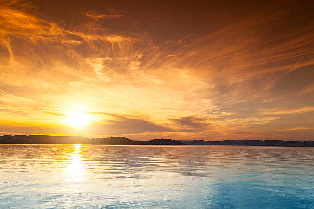 sonnenuntergang über dem wasser - sea high angle view water tranquil scene stock-fotos und bilder