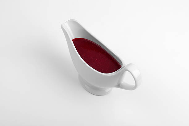 White china gravy boat isolated on white background.Front view.Single object and no people.There are meat sauce in the gravy boat.Close up. Studio shot,Side view and copy Space.Horizontal photography.