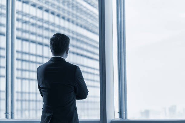 istock asian businessman standing by window looking at view 1601994173