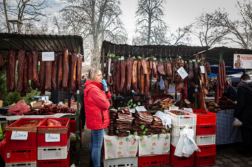 Picture of a stall of Kacarevo Market in Serbia, with cured meat hanging and drying, such as ham and sausages and dried meat called suvo meso.