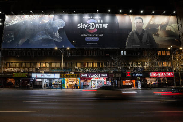 Selective blur on poster advertizing for skyshotime services on Boulevard nicolae Balcescu with cars passing & speed blur. Part of Showtime, it's a paid TV network. Picture of a poster advertizing for Skyshowtime in Bucharest City center, Romania. Showtime is an American premium television network owned by Paramount Media Networks, and is the flagship property of the namesake parent company, Showtime Networks, a part of Paramount Media Networks. Showtime's programming includes theatrically released motion pictures, original television series; boxing and mixed martial arts matches; occasional stand-up comedy specials, and made-for-TV movies. SkyShowtime is a joint-venture between Paramount Global's Showtime and Comcast which combines programming from the corporations' Paramount+ and Peacock services. SkyShowtime launched in European markets where Sky does not operate their satellite and cable services, with viewers in countries like the United Kingdom and Ireland getting access to both Paramount+ and Peacock on their Sky Q and NOW boxes along with Sky Glass television sets instead showtime stock pictures, royalty-free photos & images