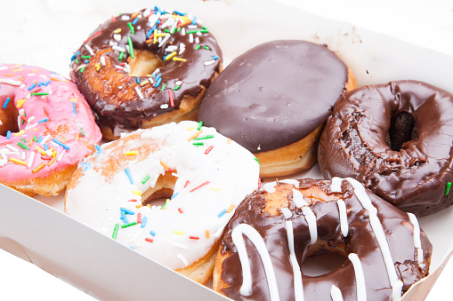squashed donuts in a box on white background