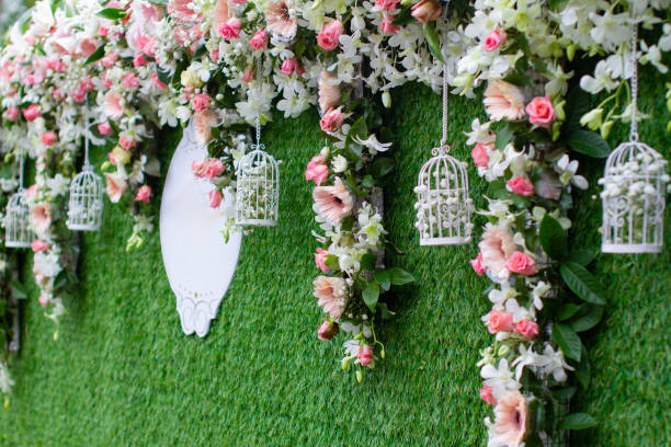 Wedding backdrop flowers in white, green, pink tones decorated with small bird cages