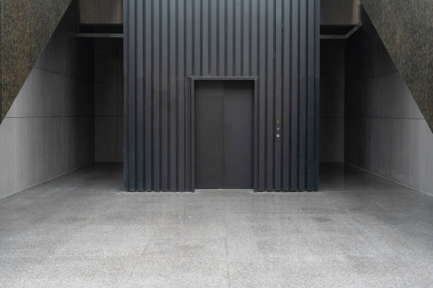 empty concrete floor in front of modern building entrance with elevator.