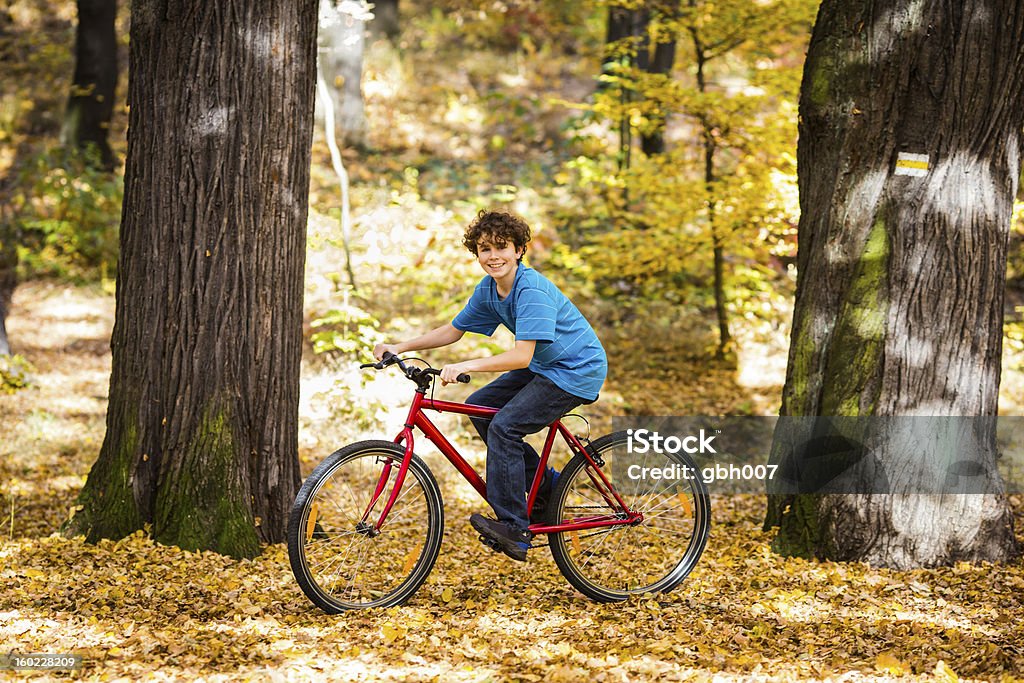 Boy riding bike en el parque de la ciudad - Foto de stock de 14-15 años libre de derechos