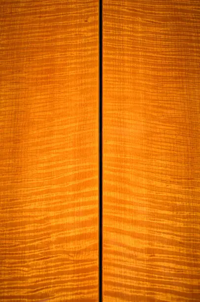 Back side of a high-end handmade acoustic guitar, made of flamed maple.
