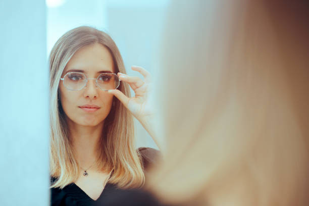 istock Woman Wearing Hexagonal Eyeglasses Looking in the Mirror 1602289287