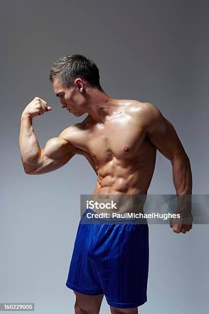 Muscular Flexión De Brazo Los Músculos Hombre Joven En Deportes De Ajuste Foto de stock y más banco de imágenes de Adulto