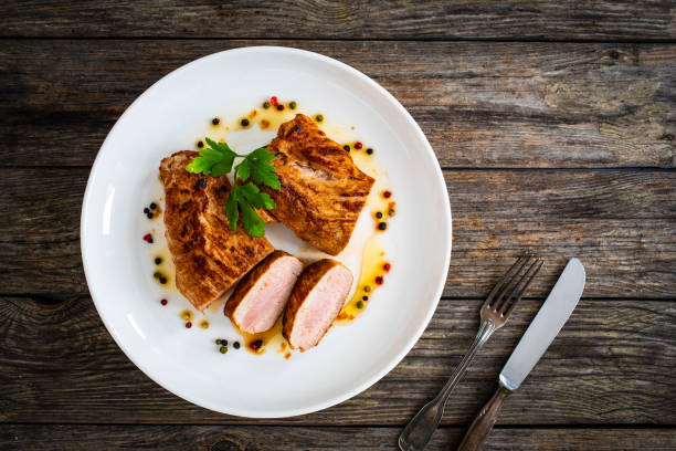 Roast pork loin in sauce  on wooden table