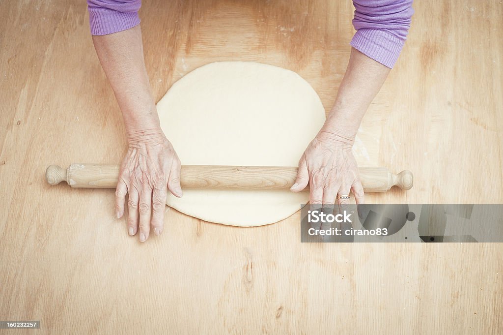 Femme âgée aplatissement pâte avec le Rouleau à pâtisserie - Photo de En bois libre de droits