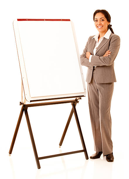 Hispânica Mulher de negócios de pé ao lado de uma tela Cavalete - foto de acervo