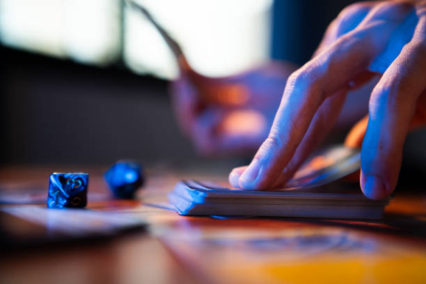 A man drawing trading card game from a deck on a table A man drawing trading card game from a deck on a table child gambling chip gambling poker stock pictures, royalty-free photos & images