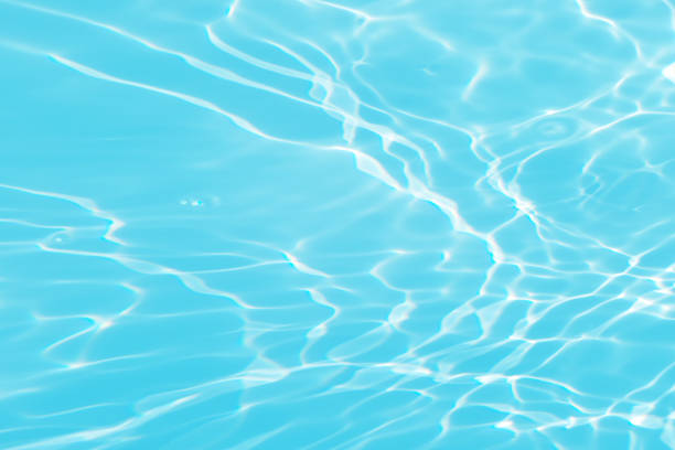 istock Blue water with ripples on the surface. Defocus blurred transparent blue colored clear calm water surface texture with splashes and bubbles. Water waves with shining pattern texture background. 1602395914