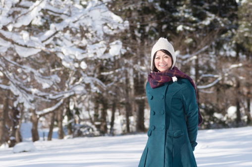 Young Asian woman in winter park.