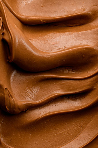 Chocolate ganache formed in waves. Chocolate cream to fill or decorate desserts or cakes. Vloseup view.