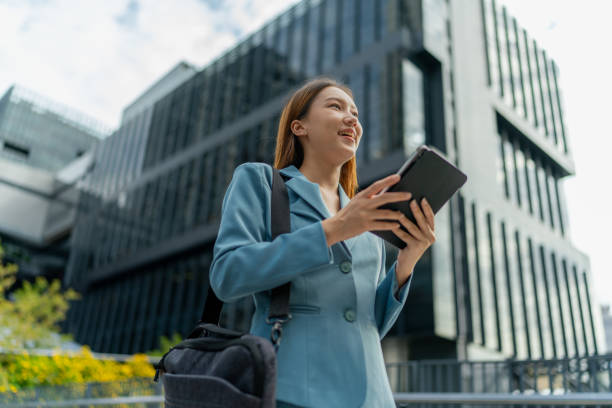 istock Efficiency Unleashed. Young Asian Businesswoman Empowers Business on the Go With A Digital Tablet Against a Contemporary Corporate Buildings in a Central Business District 1602493311