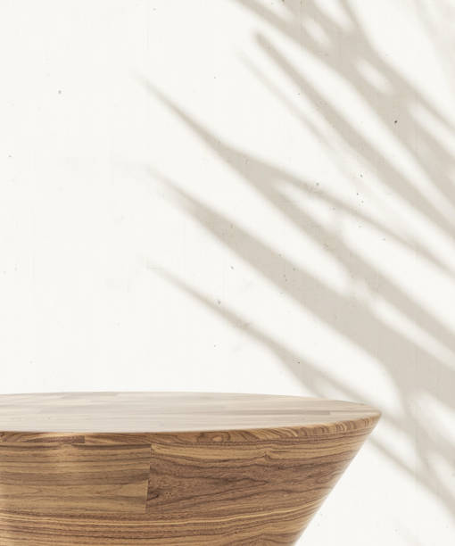 istock Minimal, modern, round wooden pedestal side table podium, tropical palm tree in sunlight, leaf shadow on white cement wall 1602506904