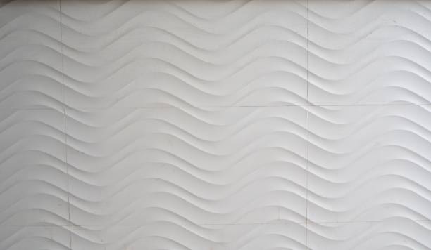 istock Closeup of a white, modern building wall with wavy patterns 1602511101