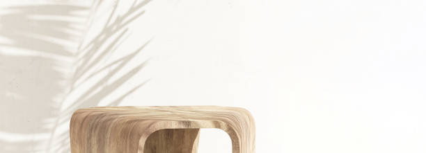istock Modern geometric design wooden pedestal side table podium in sunlight, palm tree leaf shadow on white cement wall 1602512677