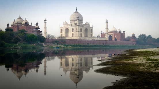 Natural colors of Taj Mahal in the early spring,  cloudy morning view with water reflection of Jamuna river.