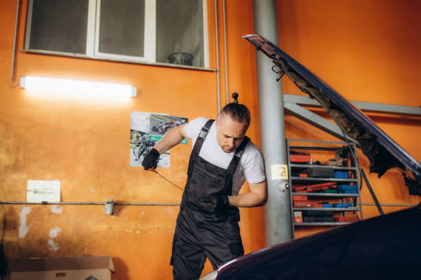istock Mechanic checking oil level in a car workshop 1602545899